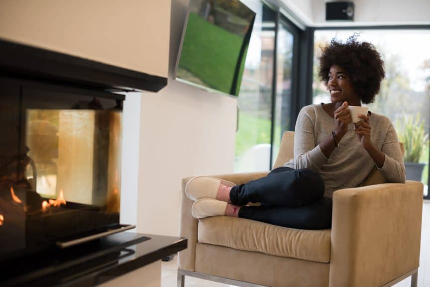 Woman in Chair in Front of Fireplace